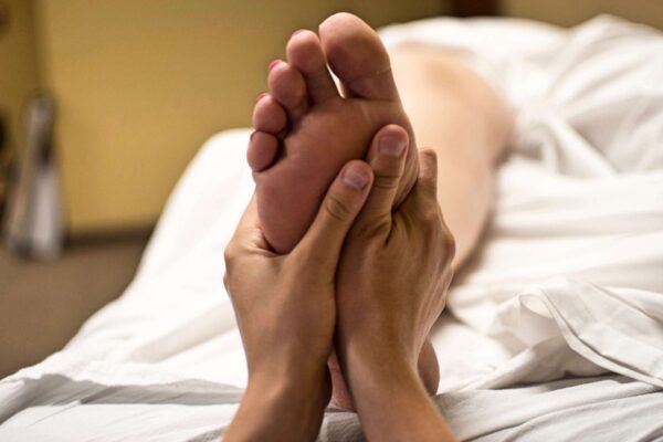 Le Corps sous la Main - La Photo montre les mains d'une masseuse en train de masser un pied - Réflexologie plantaire - Massage des pieds - Massages Belleville en Beaujolais